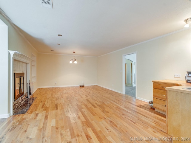 unfurnished living room featuring light wood-style floors, ornamental molding, visible vents, baseboards, and a notable chandelier