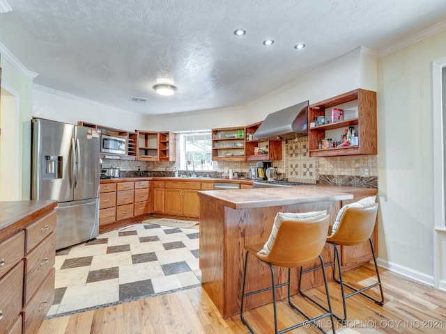 kitchen featuring visible vents, open shelves, wall chimney range hood, a peninsula, and stainless steel appliances