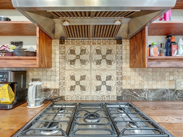 kitchen with stainless steel stove, ventilation hood, and backsplash