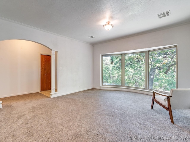 unfurnished living room with ornamental molding, visible vents, arched walkways, and carpet