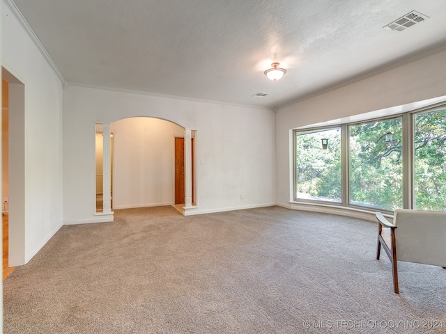 unfurnished room featuring ornamental molding, carpet floors, ornate columns, and a textured ceiling