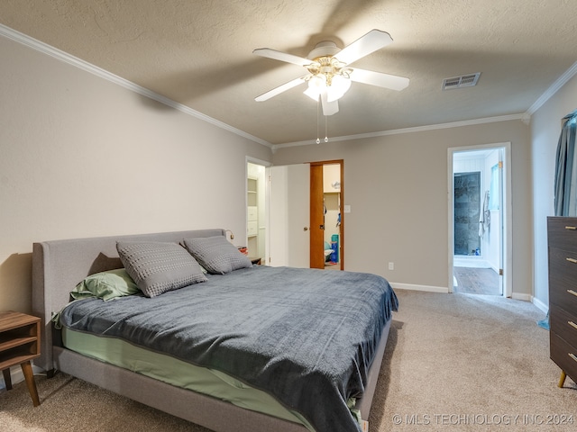 carpeted bedroom with ornamental molding, ensuite bathroom, ceiling fan, and a textured ceiling