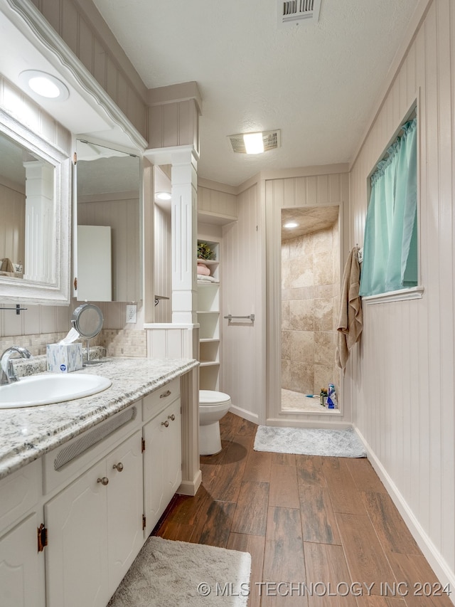 bathroom featuring toilet, walk in shower, vanity, and wood-type flooring