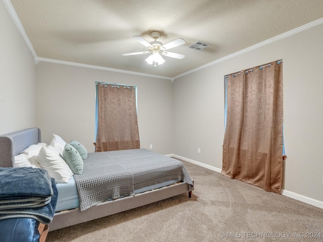 carpeted bedroom with a ceiling fan, baseboards, ornamental molding, and visible vents