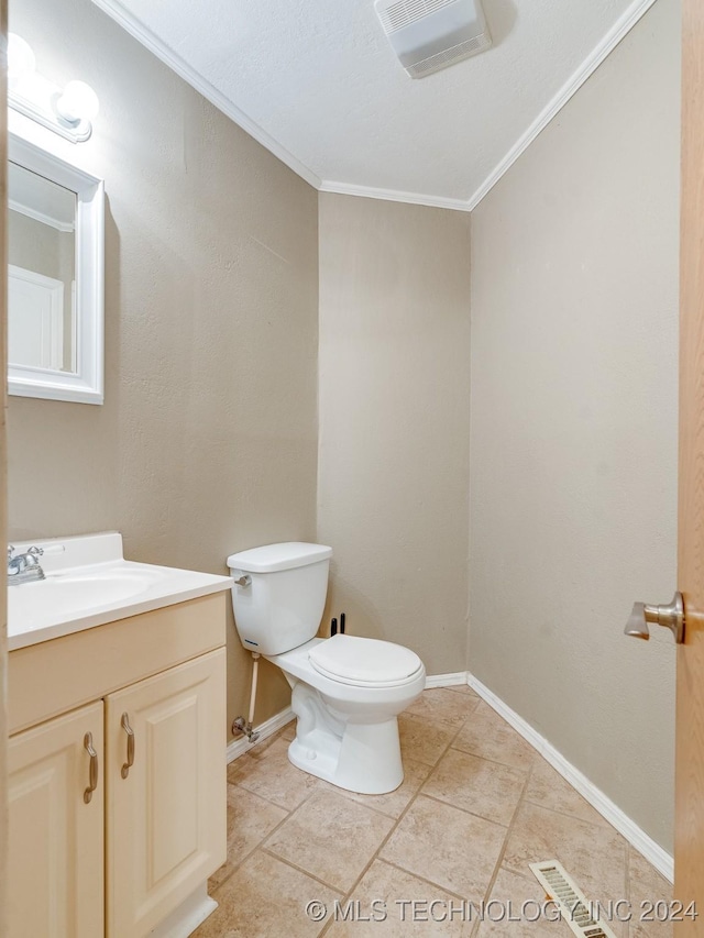 half bath featuring toilet, crown molding, vanity, and baseboards