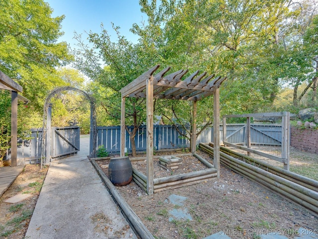 view of yard featuring fence, a pergola, and a gate