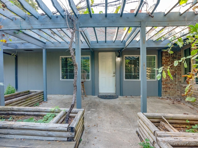 entrance to property with a patio area and a pergola