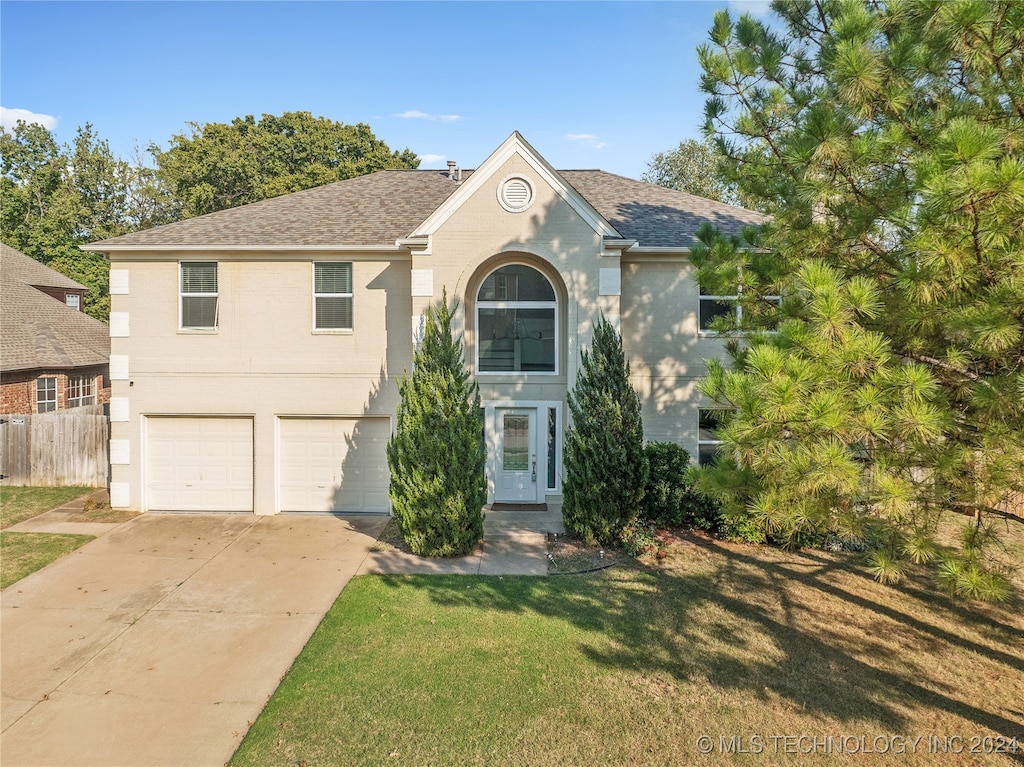 view of front of house with a garage and a front lawn