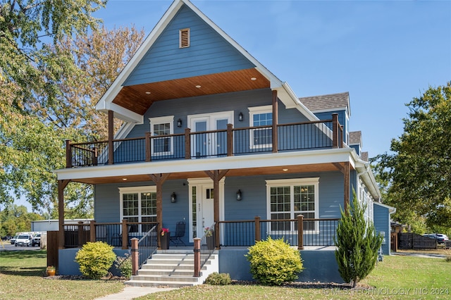 view of front facade with a porch, a front yard, and a balcony