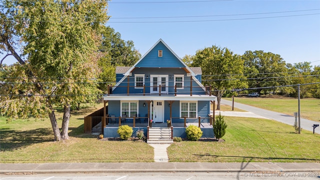 view of front of home with a porch, a balcony, and a front lawn