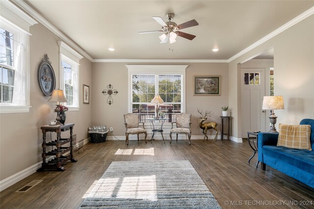 sitting room with a healthy amount of sunlight, crown molding, and dark wood-type flooring