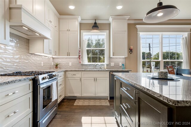 kitchen with premium range hood, hanging light fixtures, white cabinetry, and high end range