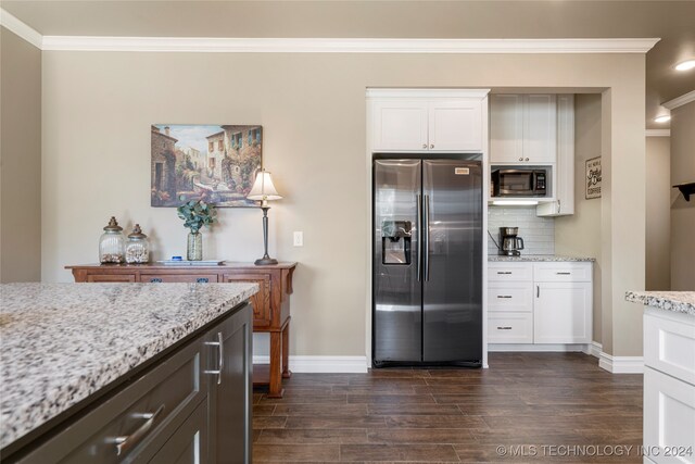 kitchen with tasteful backsplash, light stone countertops, stainless steel appliances, and white cabinets