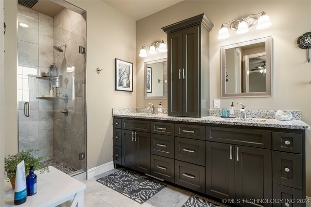 bathroom with ceiling fan, vanity, tile patterned flooring, and a shower with door