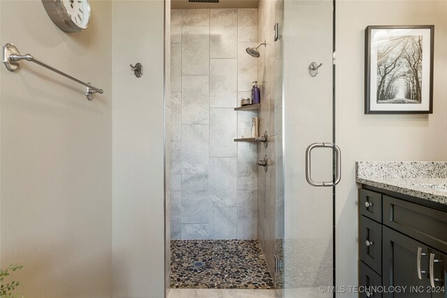 bathroom featuring vanity and a shower with door