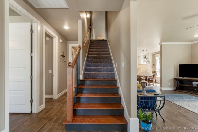 stairway with crown molding and hardwood / wood-style floors