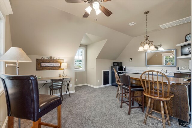 dining space featuring lofted ceiling, ceiling fan with notable chandelier, and carpet