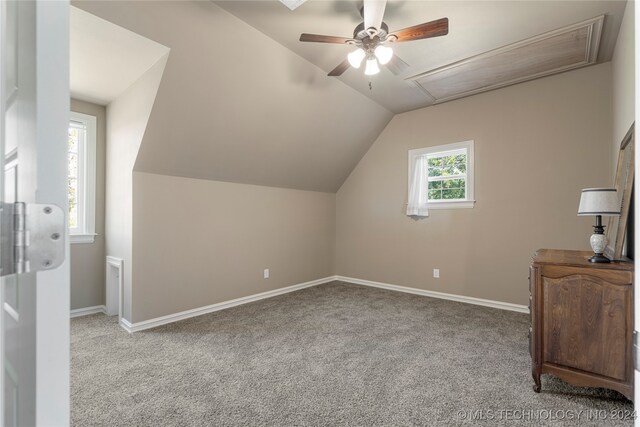 bonus room with light carpet, ceiling fan, and vaulted ceiling