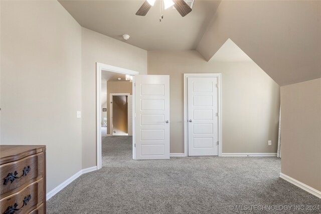 unfurnished bedroom with a closet, vaulted ceiling, carpet, and ceiling fan