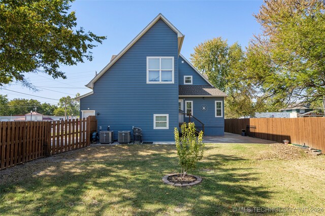 back of property with a yard, a patio area, and central air condition unit