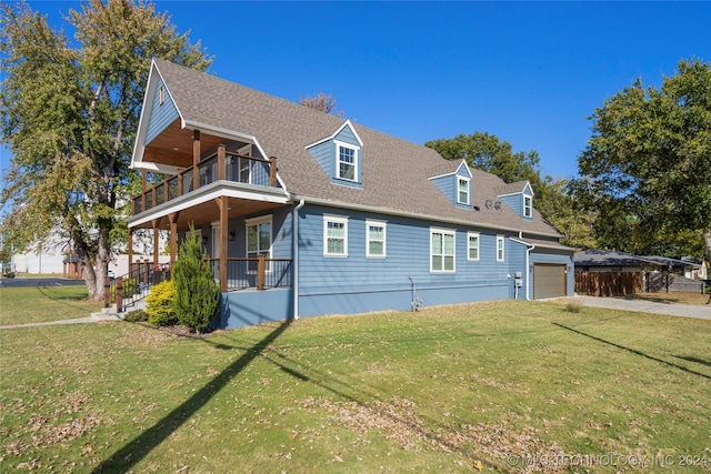 view of front of house featuring a porch, a balcony, a front yard, and a garage