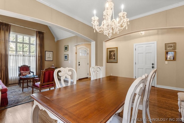 dining space with ornamental molding, a notable chandelier, lofted ceiling, and hardwood / wood-style floors