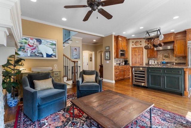 living room with ceiling fan, crown molding, wine cooler, and light hardwood / wood-style floors