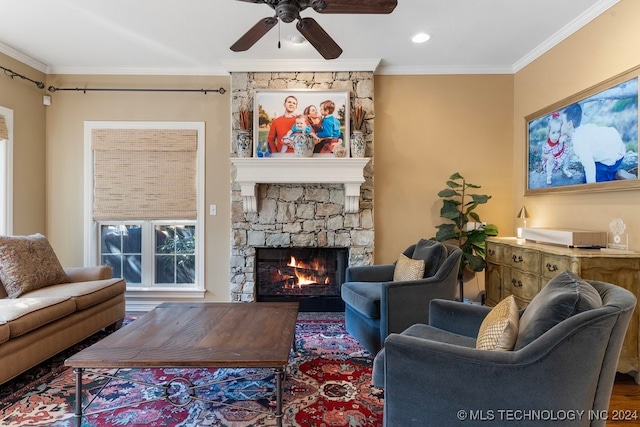 living room with ceiling fan, a fireplace, crown molding, hardwood / wood-style floors, and a wealth of natural light