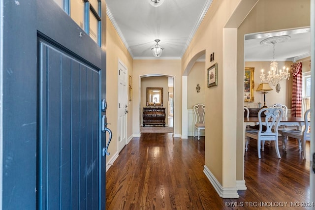 entryway with ornamental molding, an inviting chandelier, and dark hardwood / wood-style flooring