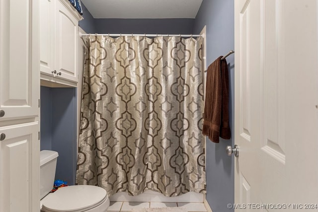 bathroom featuring a shower with curtain, tile patterned floors, and toilet