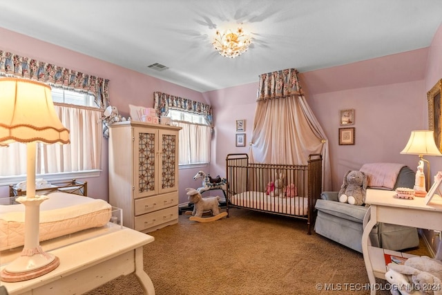 carpeted bedroom featuring a nursery area