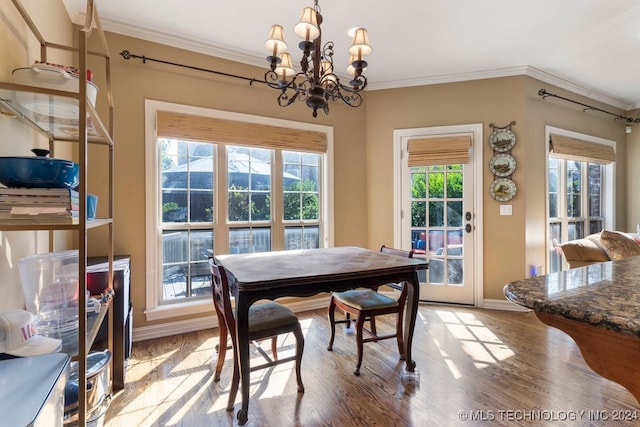 dining room featuring light hardwood / wood-style floors, crown molding, an inviting chandelier, and a wealth of natural light