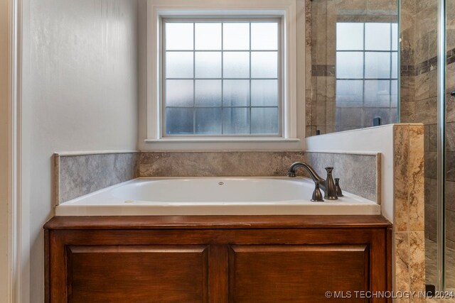 bathroom featuring separate shower and tub