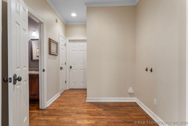 corridor featuring wood-type flooring and ornamental molding