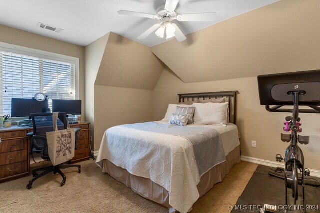 bedroom with ceiling fan, light colored carpet, and vaulted ceiling