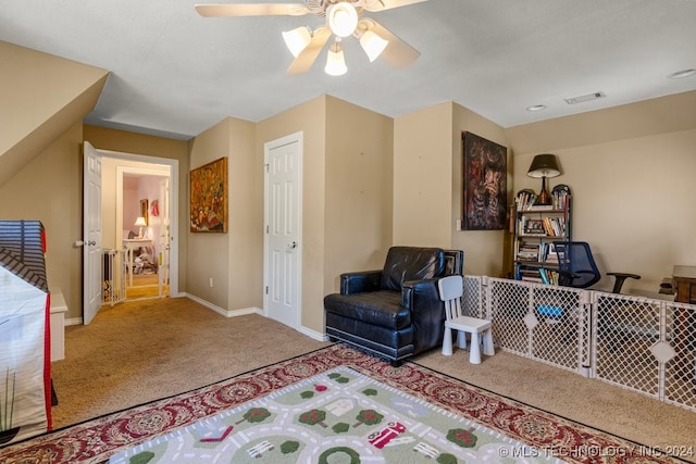 sitting room with ceiling fan and carpet flooring