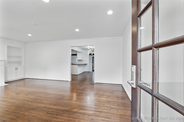 unfurnished living room featuring dark hardwood / wood-style floors and crown molding