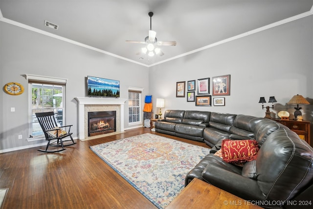 living room featuring dark wood-type flooring, ornamental molding, and ceiling fan