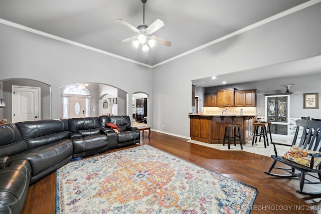 living room featuring ceiling fan, dark hardwood / wood-style floors, and crown molding