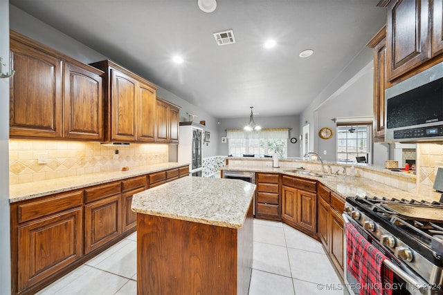 kitchen with kitchen peninsula, pendant lighting, sink, and stainless steel appliances