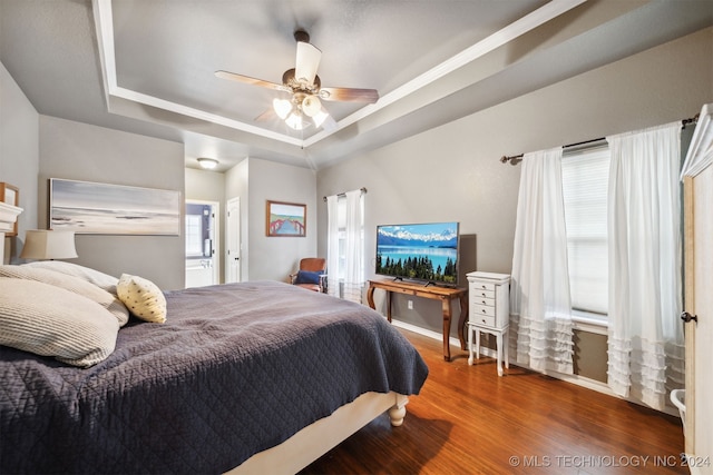 bedroom featuring multiple windows, ceiling fan, dark hardwood / wood-style flooring, and a raised ceiling