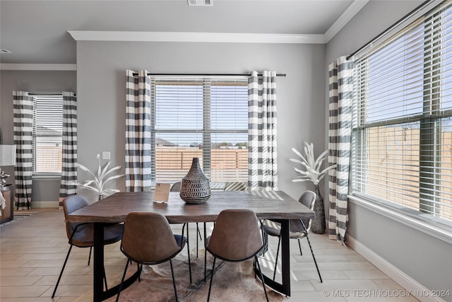 dining area featuring a healthy amount of sunlight and crown molding