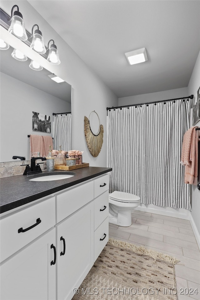 full bathroom with shower / bath combo, toilet, vanity, and wood-type flooring