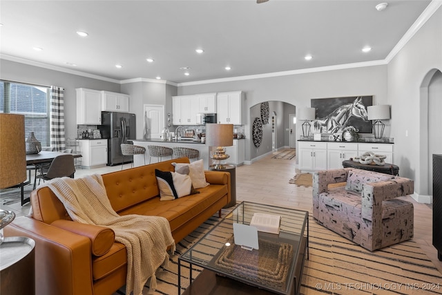 living room featuring ornamental molding and light hardwood / wood-style flooring