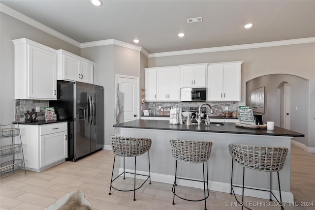 kitchen with an island with sink, sink, white cabinetry, stainless steel appliances, and crown molding