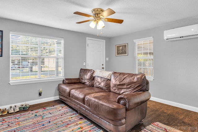 living room featuring plenty of natural light, an AC wall unit, and dark hardwood / wood-style flooring