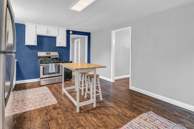 kitchen featuring appliances with stainless steel finishes, dark hardwood / wood-style floors, and white cabinets