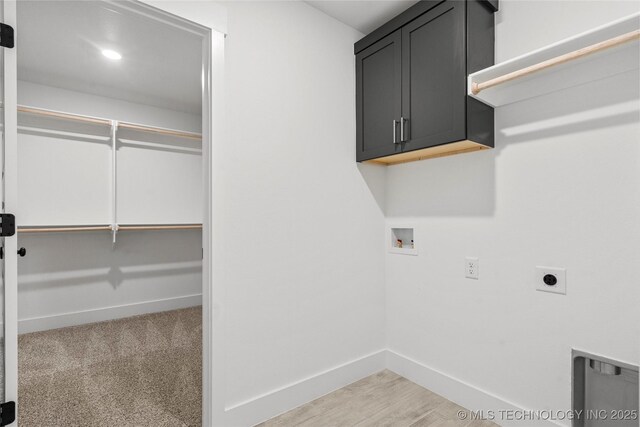 10812 S 274th Ave E, Coweta, OK 74014 - washroom featuring cabinet space, hookup for a washing machine, baseboards, electric dryer hookup, and light wood-style flooring