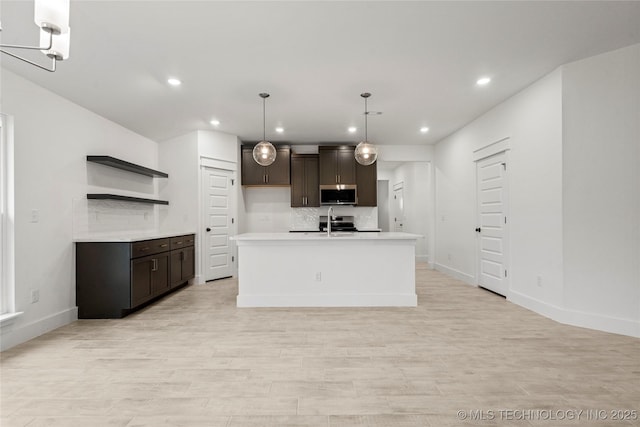 10812 S 274th Ave E, Coweta, OK 74014 - kitchen with stainless steel microwave, a sink, dark brown cabinetry, recessed lighting, and light countertops