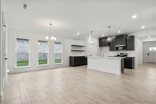 10812 S 274th Ave E, Coweta, OK 74014 - kitchen featuring appliances with stainless steel finishes, a sink, open floor plan, dark cabinets, and recessed lighting